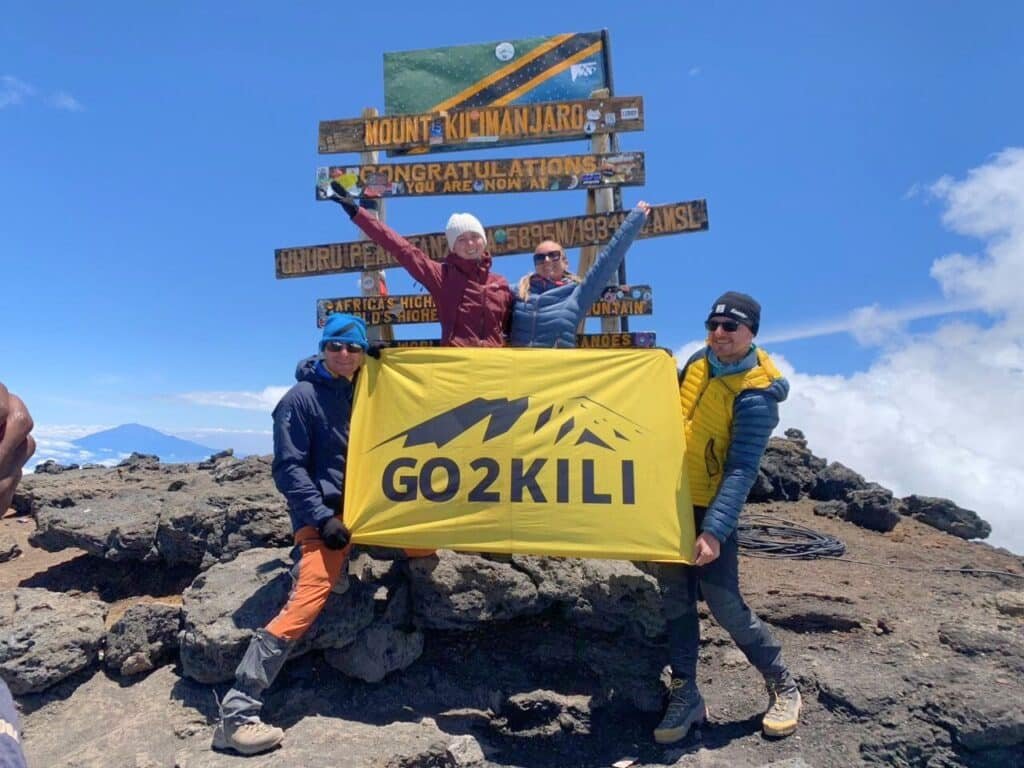 Mount Kilimanjaro climbers celebrating at the summit